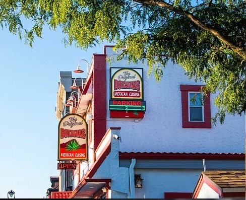 Botanas Restaurant exterior signs framed by a leafy tree on Milwaukee's South Side